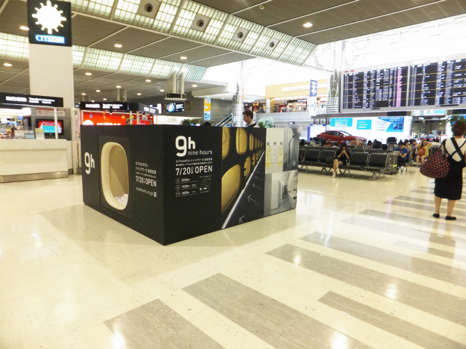 A capsule-model stood near the check-in desks at Narita Airport.